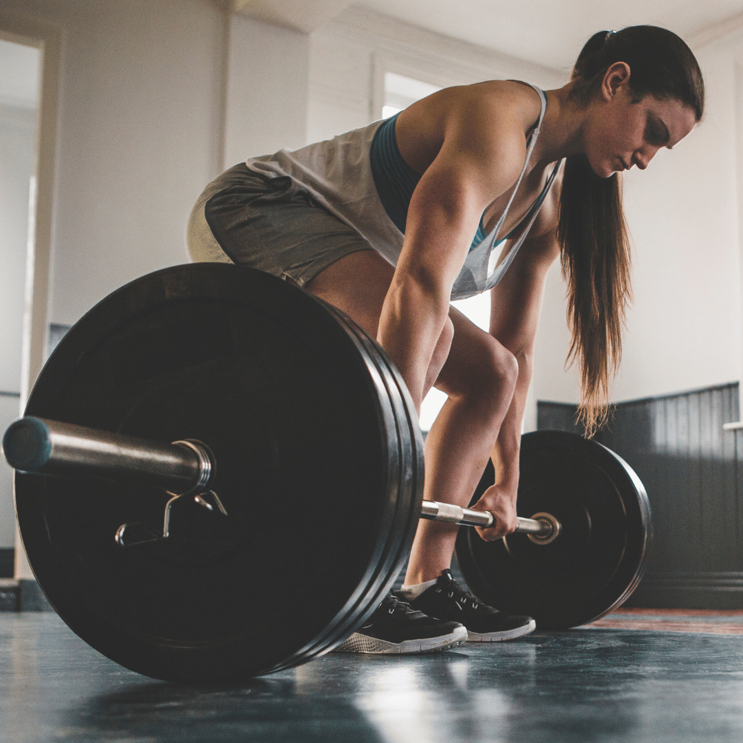 leadership-and-resilience-strength A woman in workout clothing about to deadlift a very large weight. She looks determined.