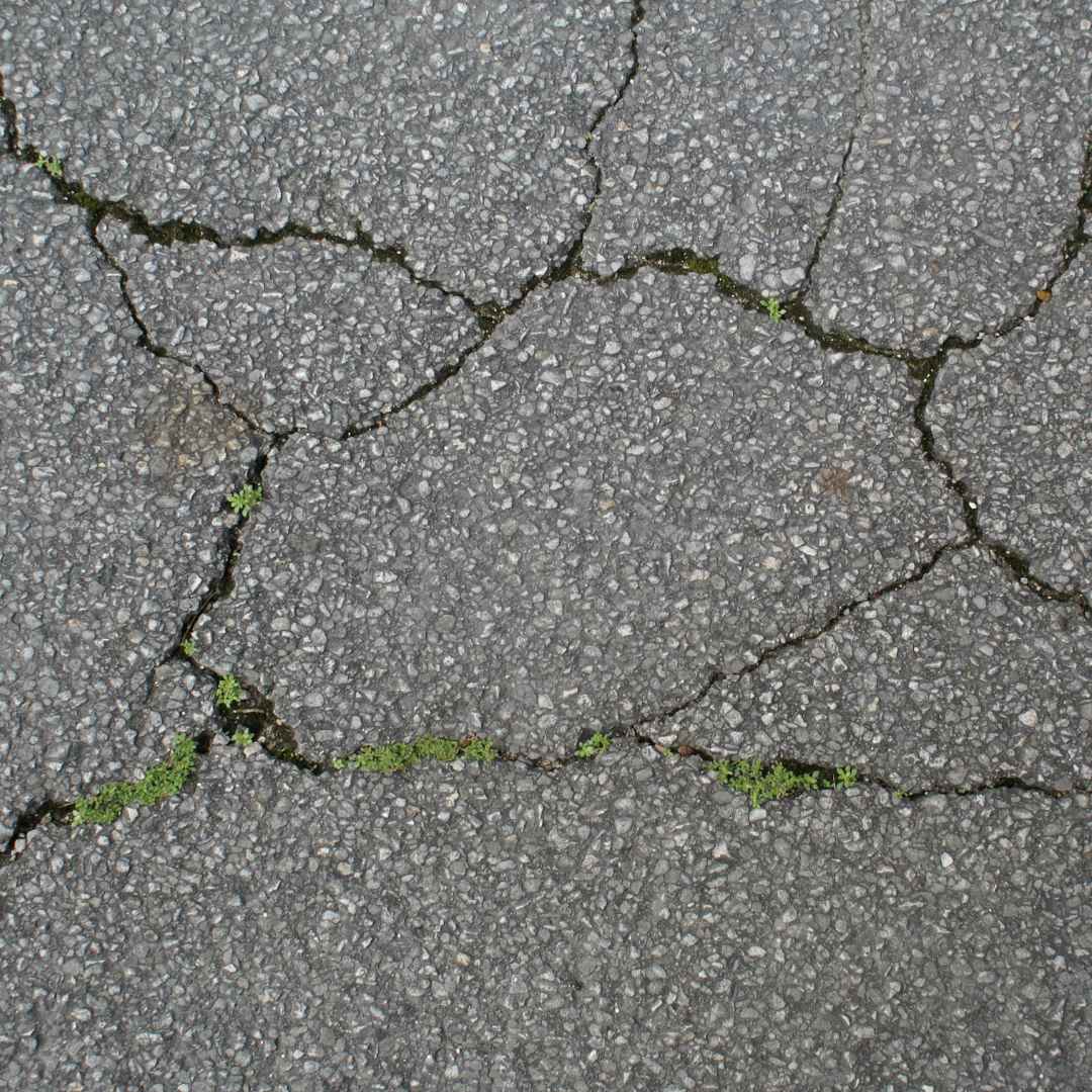 projects-falling-through-cracks-blog top-down view of a cracked tarmac pavement.