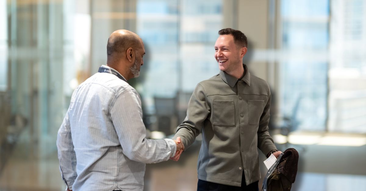 Inform change manager Jack smiles warmly and shakes hands with a client